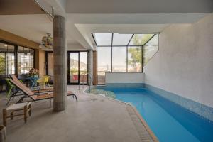 a house with a swimming pool and a dining room at Hotel Livin in Tbilisi City