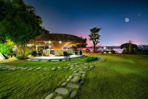 a building with a stone path in a park at NSH Riverside Glamping Resort in Hanoi