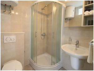a bathroom with a shower and a toilet and a sink at Apartment Karmela in Primošten +25 photos