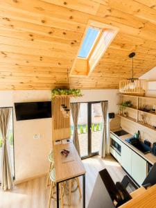 a kitchen with wooden ceilings and a table in a room at Royal Hill-Queen Chalet -Bran, Mountain View and Hot Tub in Sohodol