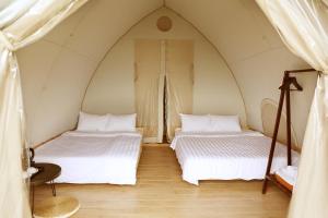 a bedroom with two beds in a tent at NSH Riverside Glamping Resort in Hanoi +37 photos