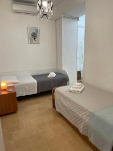 a bedroom with two beds and a table and a chandelier at Sweet Home Sofia in Norma