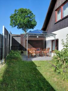 a patio with two wooden benches under a canopy at Gemütliche Wohnung Buchholz i d N in Buchholz in der Nordheide
