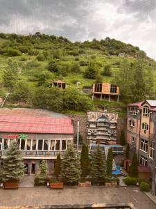 a group of buildings and a hill with trees at The House Hotel Goris in Goris