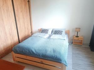 a bedroom with a bed with a blue comforter at Przytulny Kąt in Żory