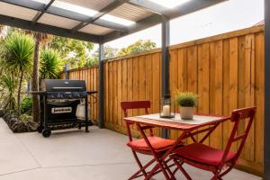 a patio with a grill and a table and chairs at Golfside Getaway by Ready Set Stay in Rosebud
