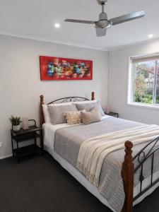 a bedroom with a bed and a ceiling fan at Golfside Getaway by Ready Set Stay in Rosebud