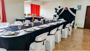 a long table with white chairs and a long table at Westside Hotel Kitale in Kitale +26 photos