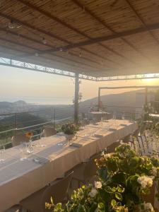 a long table with white tables and chairs with flowers at Casa dei Bruschi in Casarza Ligure