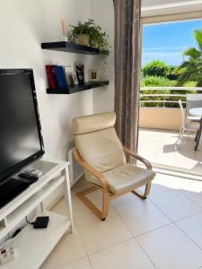 a living room with a chair and a television at wonderful sea view in Antibes