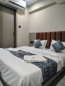 two beds sitting next to each other with towels on them at Hotel Sky Dream in Gandhinagar