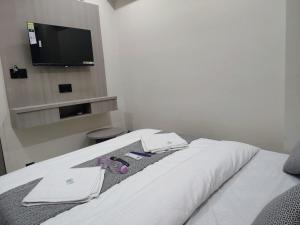 a bedroom with a bed with a tv on the wall at Hotel Sky Dream in Gandhinagar