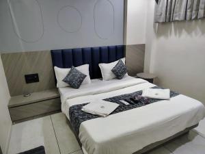 two beds in a hotel room with two trays on them at Hotel Sky Dream in Gandhinagar +43 photos