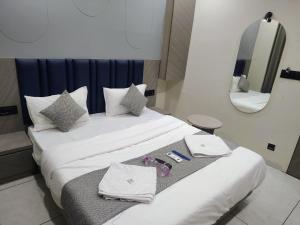 a hotel room with a bed with towels and a mirror at Hotel Sky Dream in Gandhinagar