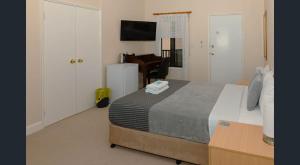 a bedroom with a bed and a desk and a television at Nest & Rest York in York