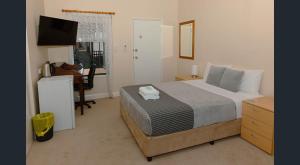 a bedroom with a bed and a desk and a television at Nest & Rest York in York
