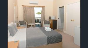a bedroom with a large bed and a balcony at Nest & Rest York in York