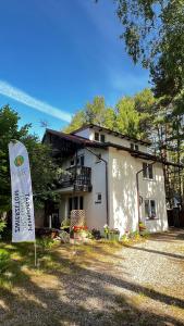 a small house with a sign in front of it at Dziupla Dębki in Dębki