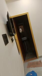 a room with a door and a television on a wall at Kanha Hotel in Kānpur