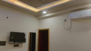 a room with a flat screen tv on a wall at Kanha Hotel in Kānpur