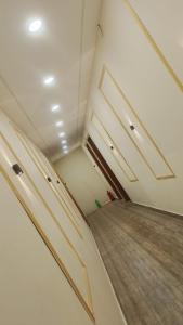 an empty room with white walls and wooden floors at Kanha Hotel in Kānpur
