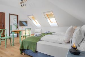 a bedroom with a bed and a table and chairs at Wathay Vendégház in Csesznek