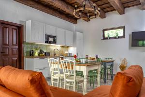 a kitchen and dining room with a table and chairs at Wathay Vendégház in Csesznek
