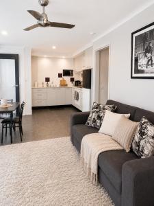 a living room with a couch and a kitchen at Golfside Getaway by Ready Set Stay in Rosebud