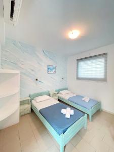 two beds in a room with a painting on the wall at Villa Dima in Perissa +69 photos