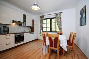 a kitchen and dining room with a table and chairs at Pension Pilsachhof in Arriach