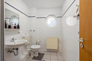 a white bathroom with a toilet and a sink at Apartments Lübeck in Lübeck +148 photos