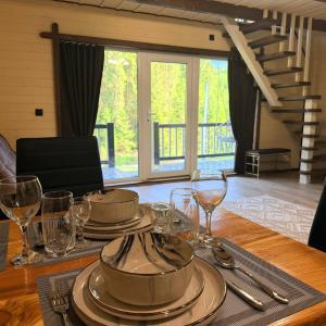 a wooden table with plates and wine glasses on it at Подих Свободи in Sloboda