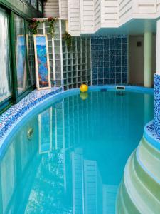 a blue swimming pool with a ball in the water at Guest House Krista in Jūrmala