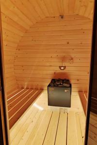 a small wooden sauna with a stove in it at Klimatyzowany Domek z Sauną w lesie z posesją na wyłączność Mazury Prażmowo in Prażmowo