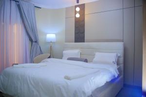 a bedroom with a large bed with white sheets at Moorlandhouse & SPA in Migori