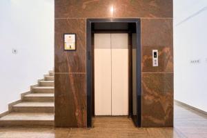 a hallway with a white door and stairs at Itsy Hotels R S Bhavan, 2 Km From MIT Gate in Manipal