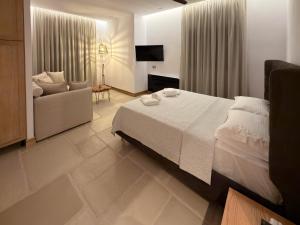 a bedroom with a bed and a couch and a chair at Centaure Inn in Agios Dimitrios