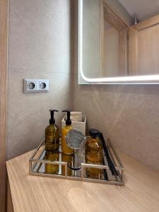 a glass shelf with two bottles on a counter in a bathroom at Centaure Inn in Agios Dimitrios +47 photos