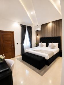 a bedroom with a large bed with a black leather seat at NO 5 Hotel in Lekki