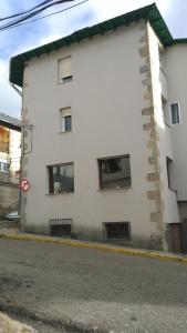 un edificio blanco al lado de una calle en Alojamientos turísticos VUT-LE-043, en Villablino