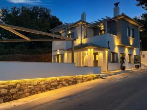 a large white house with a stone wall at Centaure Inn in Agios Dimitrios
