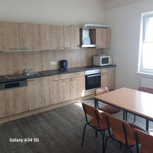 a kitchen with wooden cabinets and a table with chairs at Zimmer für Monteure in Crivitz +29 photos