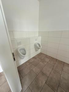 a bathroom with two urinals on the wall at Zimmer für Monteure in Crivitz