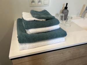 a pile of towels sitting on a bathroom counter at B&B Maaltebrug in Ghent +66 photos