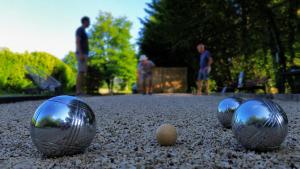 three metal balls on the ground with people in the background at Camping les Avenières in Manthes