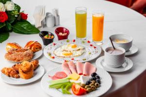 a table with plates of breakfast foods and drinks at Hotel Amur in Corbu