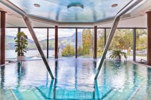 a swimming pool in a house with a view of the mountains at Belvédère Strandhotel in Spiez