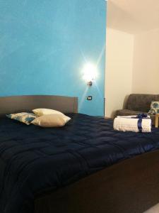 een slaapkamer met een bed met een blauwe muur bij B&B Peschici Rooms in Peschici