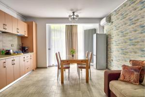 a kitchen and dining room with a table and a refrigerator at Alezzi Seaside D in Năvodari