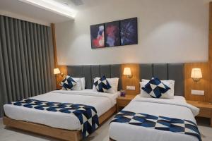 a hotel room with two beds in a room at Hotel Premji, Dwarka in Dwarka